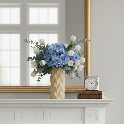 BioVase Tessera garni d’hortensias bleus et de tulipes sur une cheminée